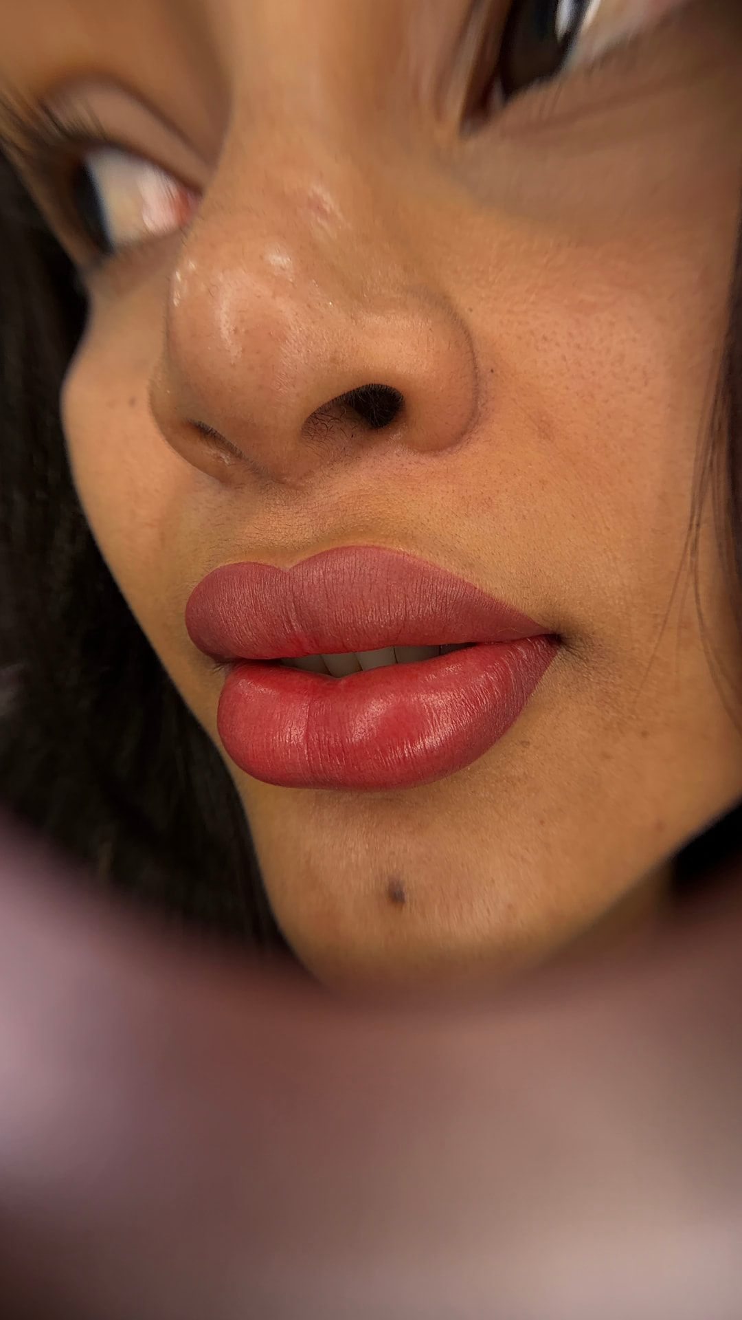 Close do resultado de micropigmentação labial com acabamento velvety, lábios em tom rosado e uniforme